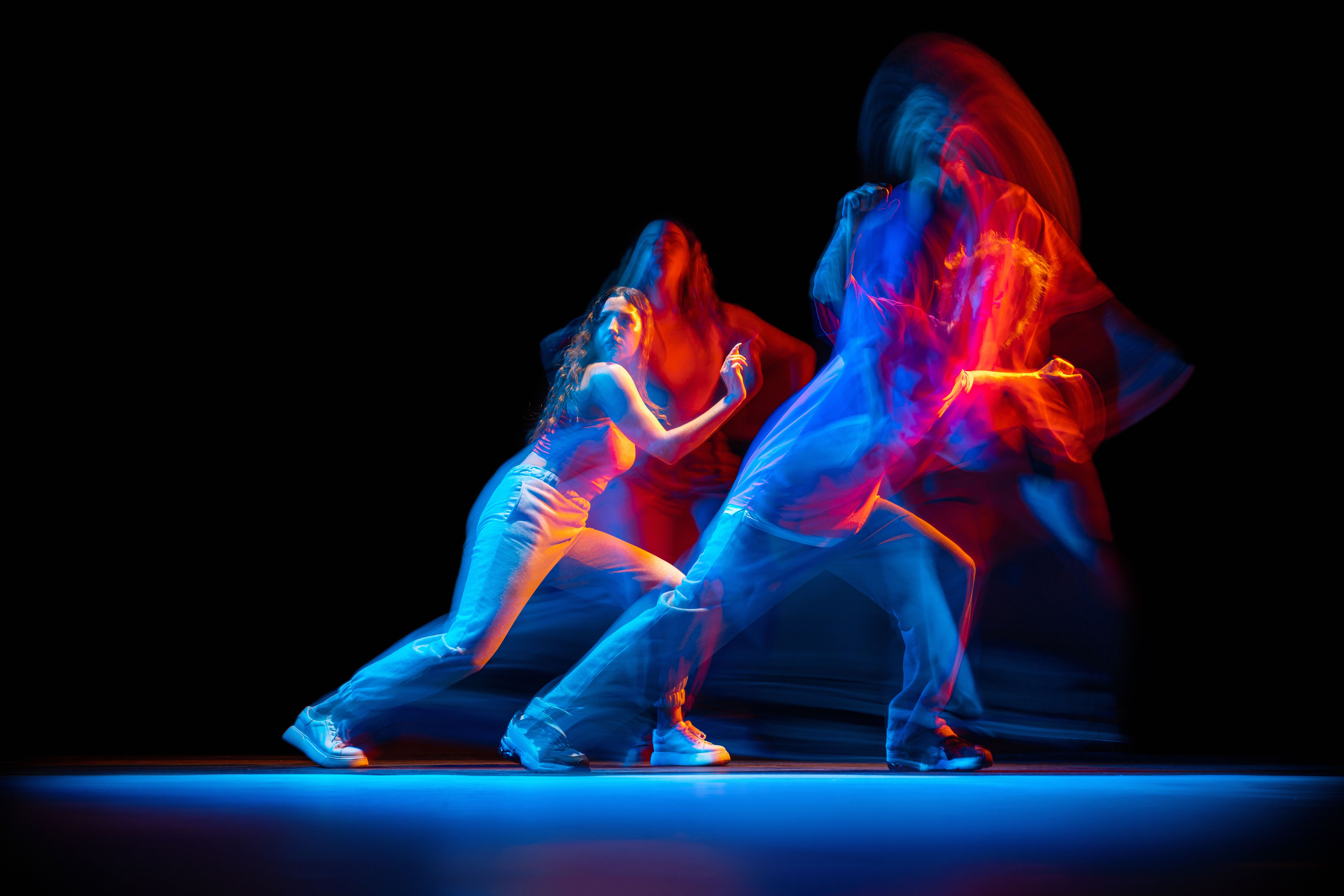 dynamic-portrait-young-man-woman-dancing-hiphop-isolated-black-background-with-mixed-lights-effect